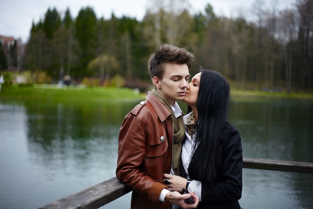 sensual portrait of beautiful romantic fashion couple standingin the park.Brunette girl