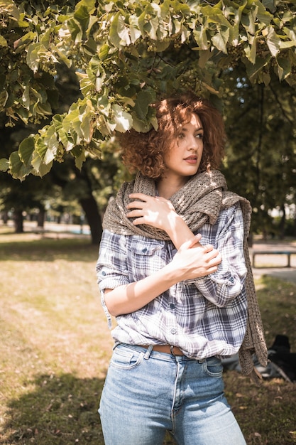 Sensual woman looking away under tree