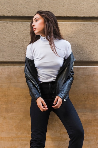 Free photo sensual young woman standing in front of wall