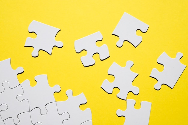 Free Photo separate white puzzle piece on yellow backdrop