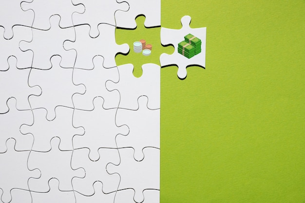 Separation of coin and bank note on puzzle on green background