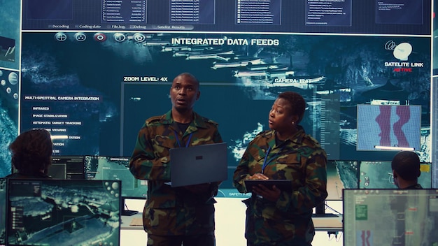 Free photo sergeant major and female soldier checking real time field data in command post