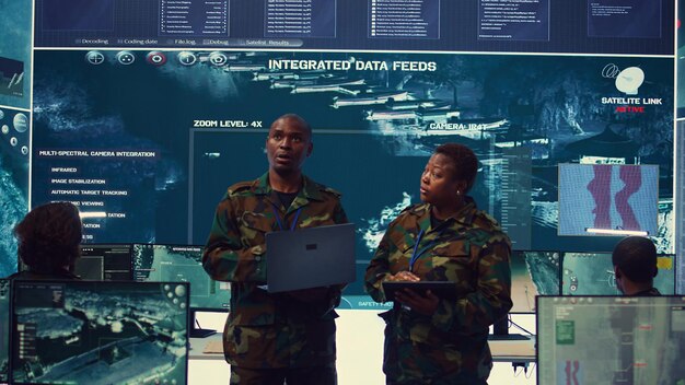 Sergeant major and female soldier checking real time field data in command post