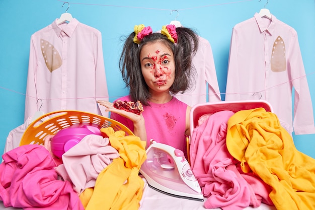 Free photo serious asian girl has two pony tails poses near two baskets of laundry