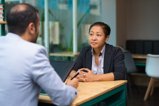 Serious Asian woman meeting with business partner