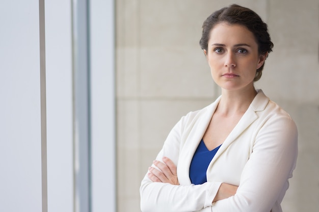 Serious Beautiful Businesswoman Standing at Window