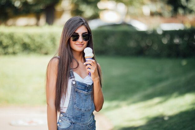 Serious beautiful girl smiles with white teeth and holds the ice cream