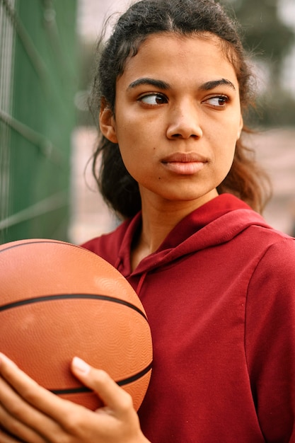 Serious black american woman playing basketball