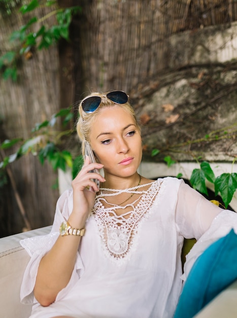 Free Photo serious blonde young woman using mobile phone