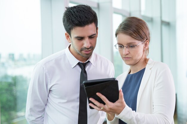 Serious business colleagues looking at touchpad