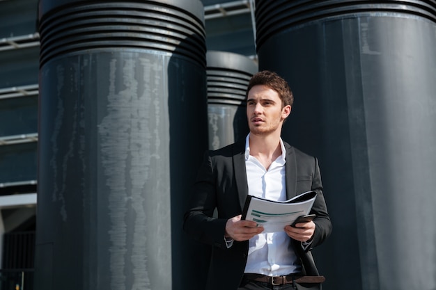 Free Photo serious businessman holding documents