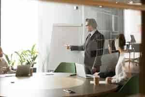 Free photo serious businessman presenting company business goals to colleagues