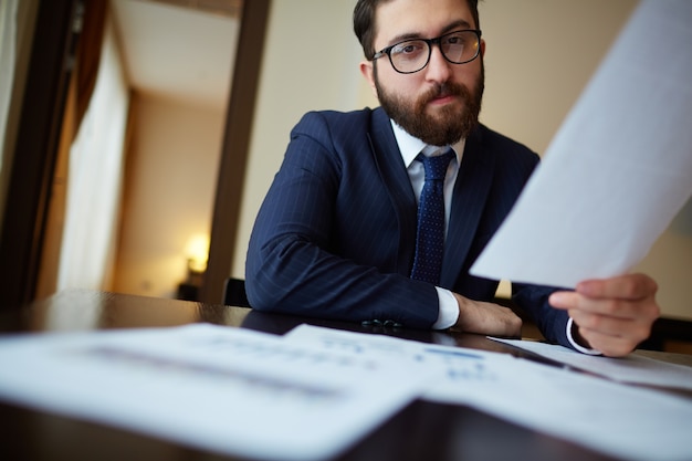 Free photo serious businessman reading a document