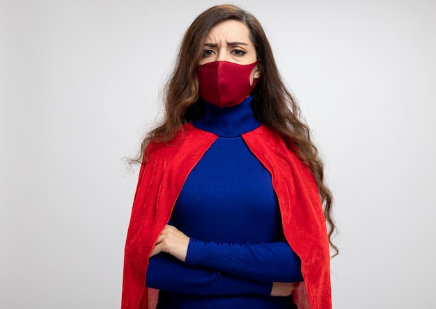 Free photo serious caucasian superhero girl with red cape wearing red protective mask