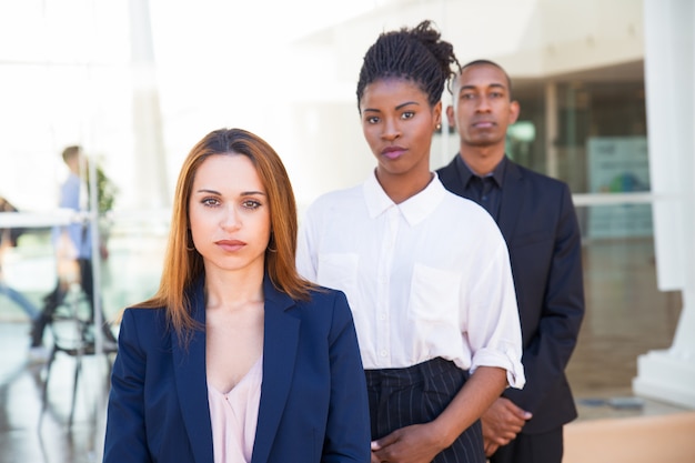 Free Photo serious confident business people standing in row