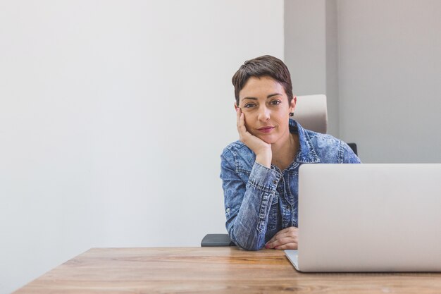 Serious employee posing with one hand on her cheek