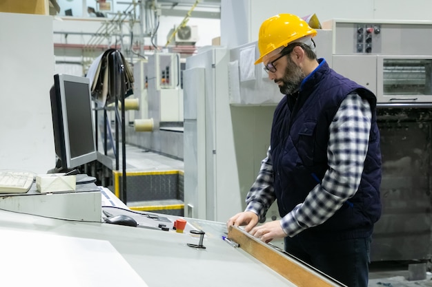 Free photo serious engineer in glasses operating machine