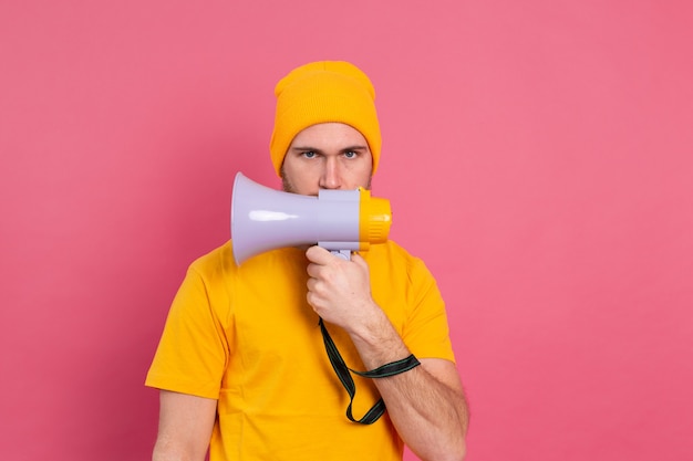 Free Photo serious european man with megaphone on pink background