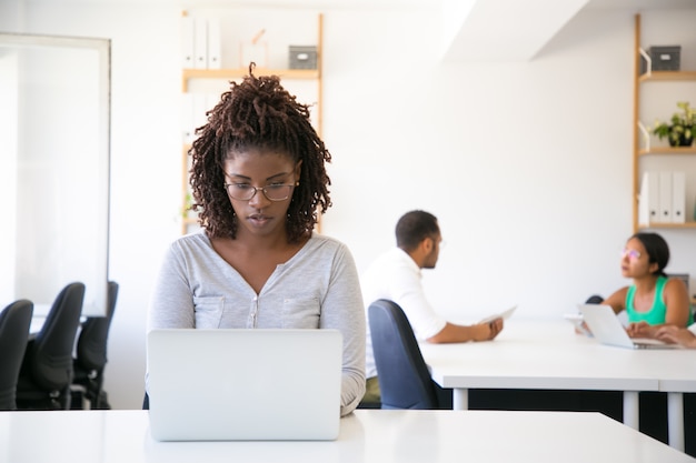 Serious excited African American employee working on computer