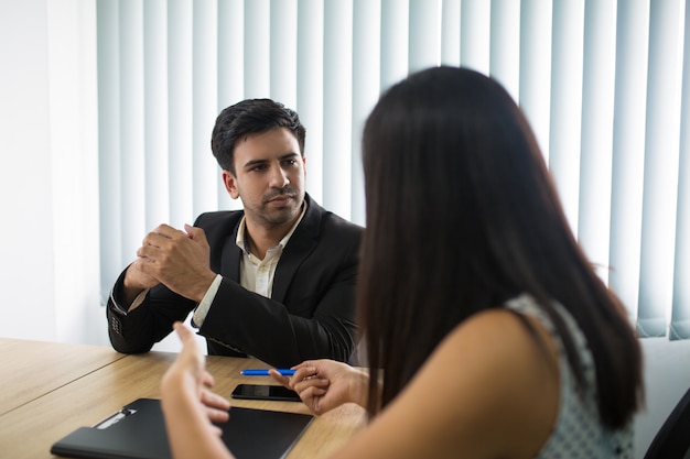 Serious executive listening to female partner or employee