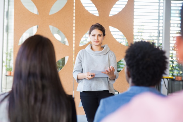 Free Photo serious female woman presenting project to classmates