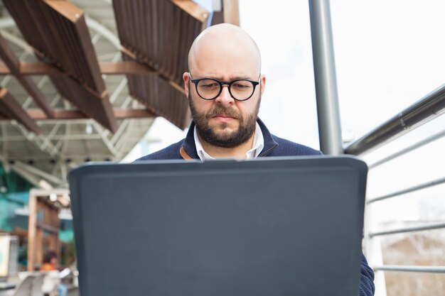 Serious focused freelancer using laptop