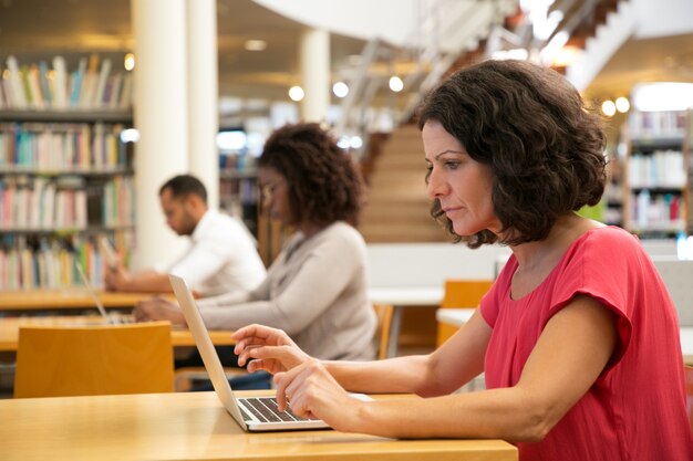 Serious focused middle aged woman working on research