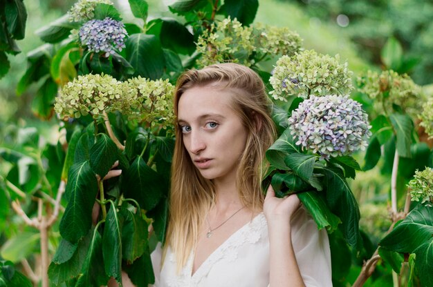 Serious girl posing next to some flowers