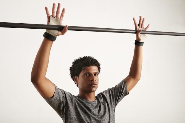 Free Photo serious looking black gymnast in gray tshirt and gymnastics hand protection preparing to grab a black carbon pullup bar, fingers outstretched, isolated on white