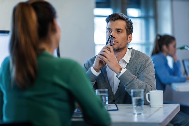 Free photo serious manager communicating with his female employee on a meeting in the office