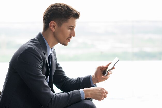 Serious Middle-aged Businessman Using Smartphone