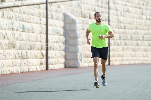 Serious Muscular Sporty Man Running on Road