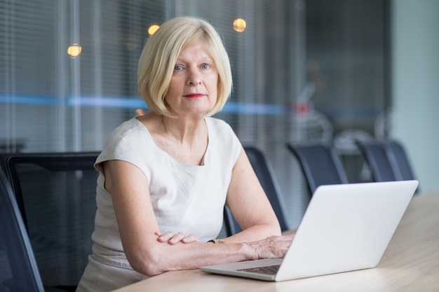 Free Photo serious senior office worker sitting in boardroom