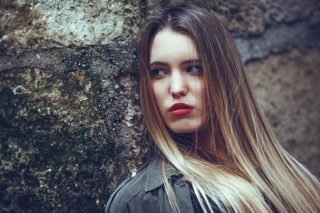 Serious teenager with long hair and red lips