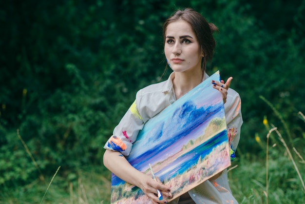 Serious woman holding a picture with both hands