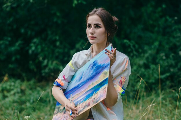 Serious woman holding a picture with both hands