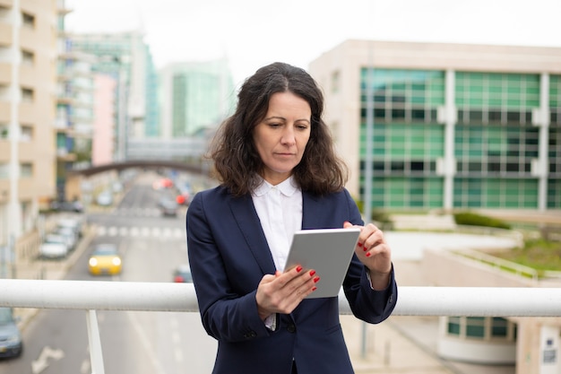 Free Photo serious woman using tablet pc