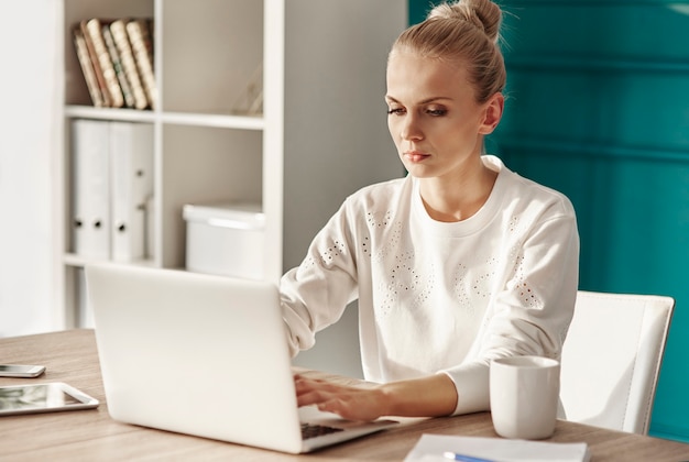 Free photo serious woman with laptop working at home office