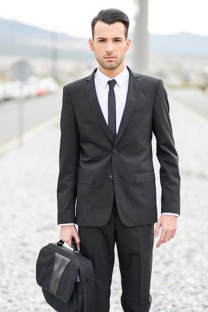 Free photo serious worker holding his briefcase