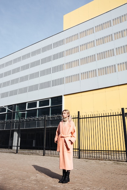 Free photo serious young blonde lady walking outdoors. looking aside.