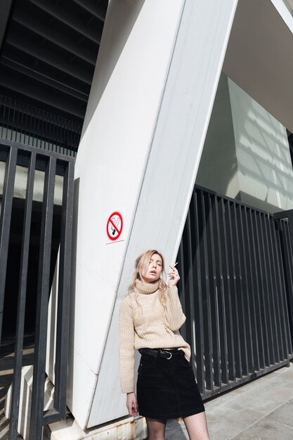 Serious young blonde lady with cigarette