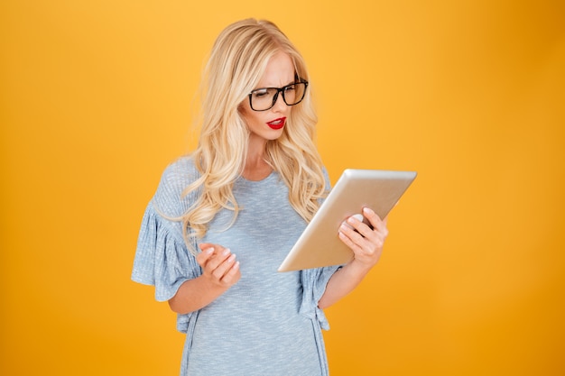 Free Photo serious young blonde woman using tablet computer.