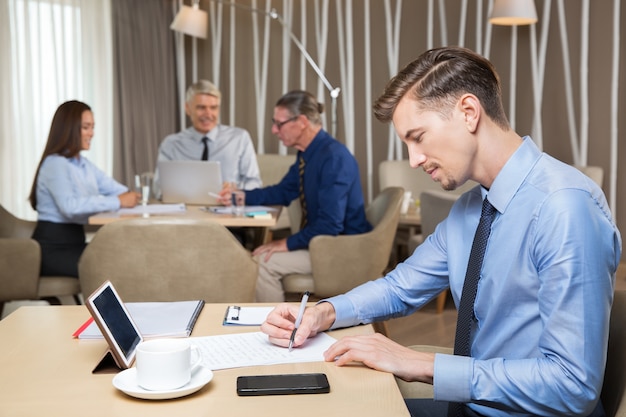 Free Photo serious young businessman and team working in cafe