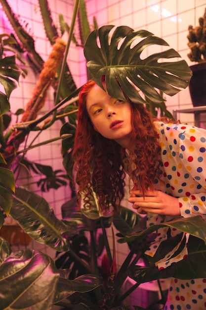 Serious young redhead curly lady standing in cafe near latrine