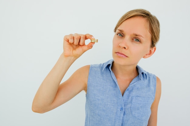 Free photo serious young woman holding coins stack