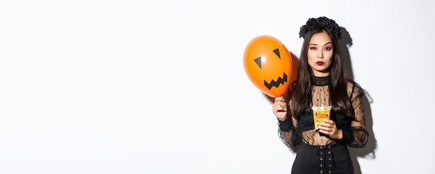 Free photo seriouslooking woman looking arrogant in witch costume trick or treating during halloween night hold