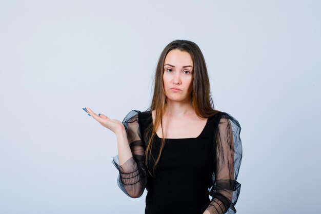 Seriously girl is pointing left with hand on white background