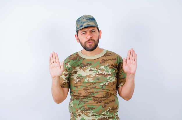 Seriously soldier is raising up and showing his handfuls on white background