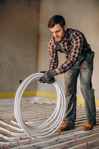 Free photo service man instelling house heating system under the floor