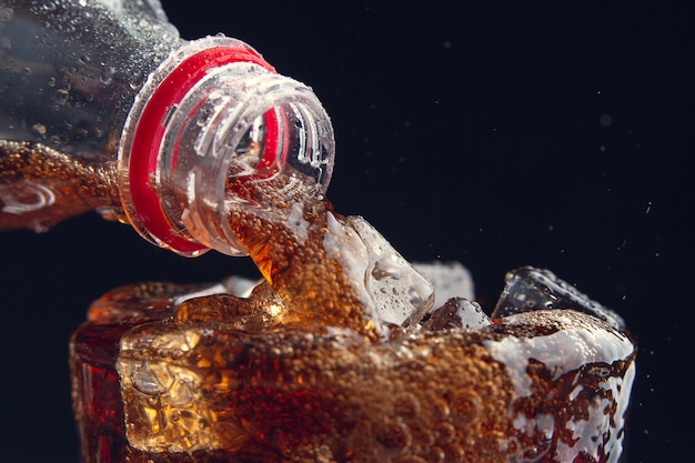 Free Photo serving a cola from a bottle to a glass full of ice